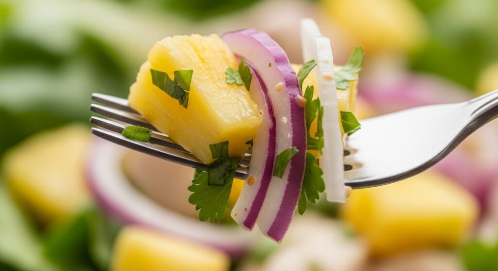 Close-up of pineapple and cucumber salad texture with fresh herbs.