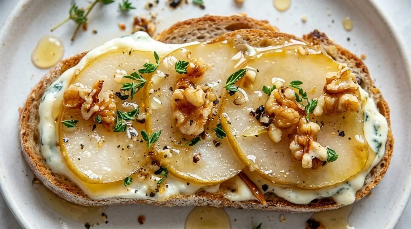 Top-down view of pear and gorgonzola crostini with honey and thyme.