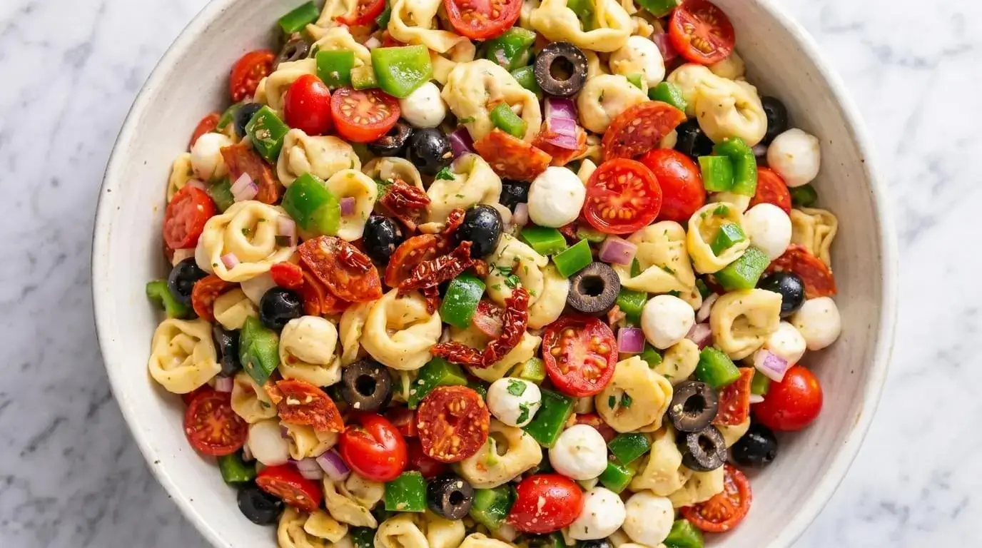 Italian tortellini and mozzarella salad with cherry tomatoes, olives and bell peppers
